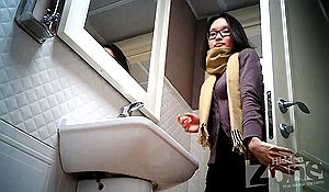 Писающая девушка в очках в общественной уборной