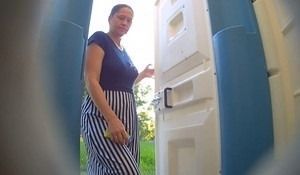 В уличном сортире подглядывают за зрелой женщиной